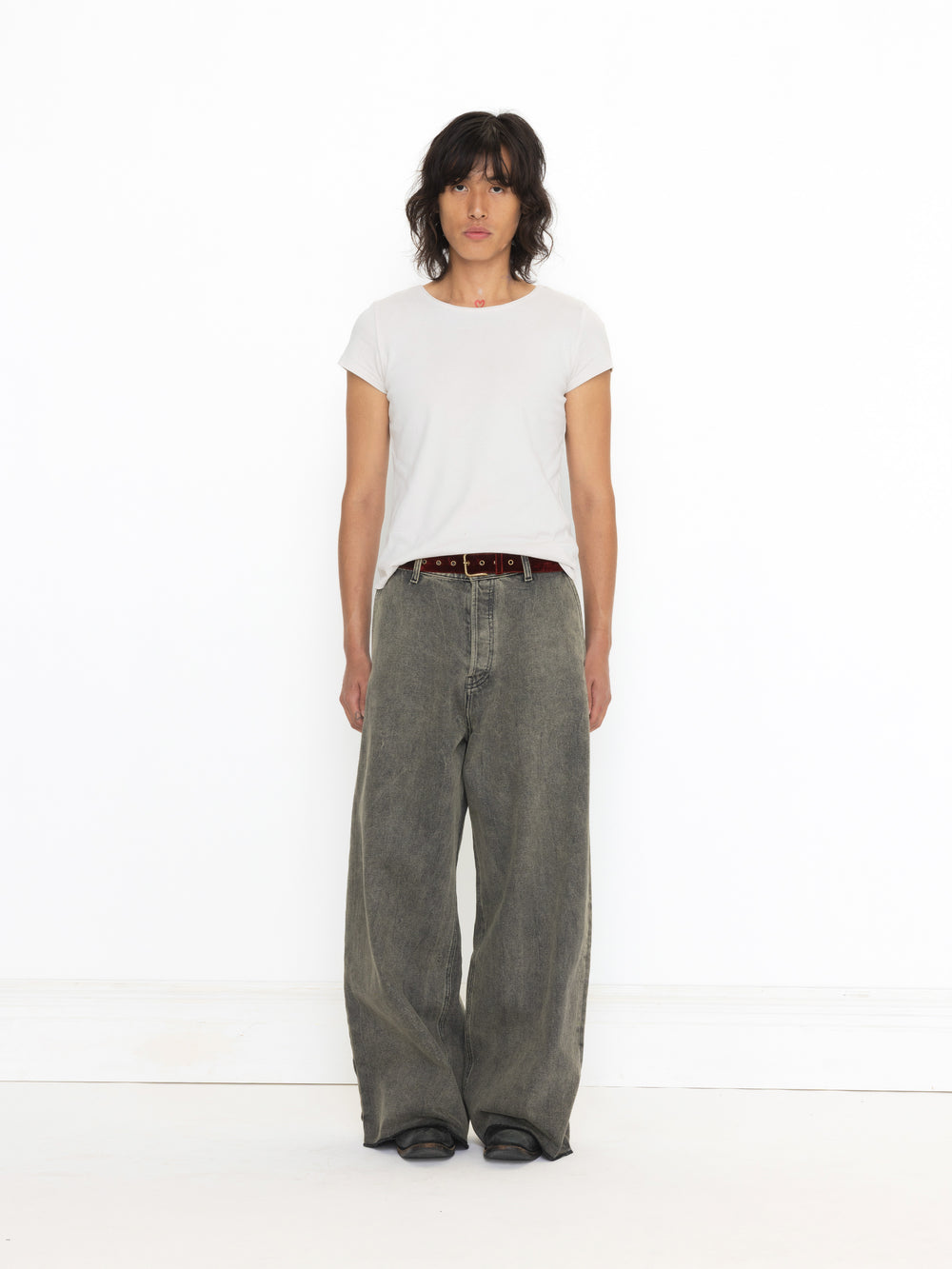 Person wearing a white t-shirt and gray wide-leg jeans on a white background