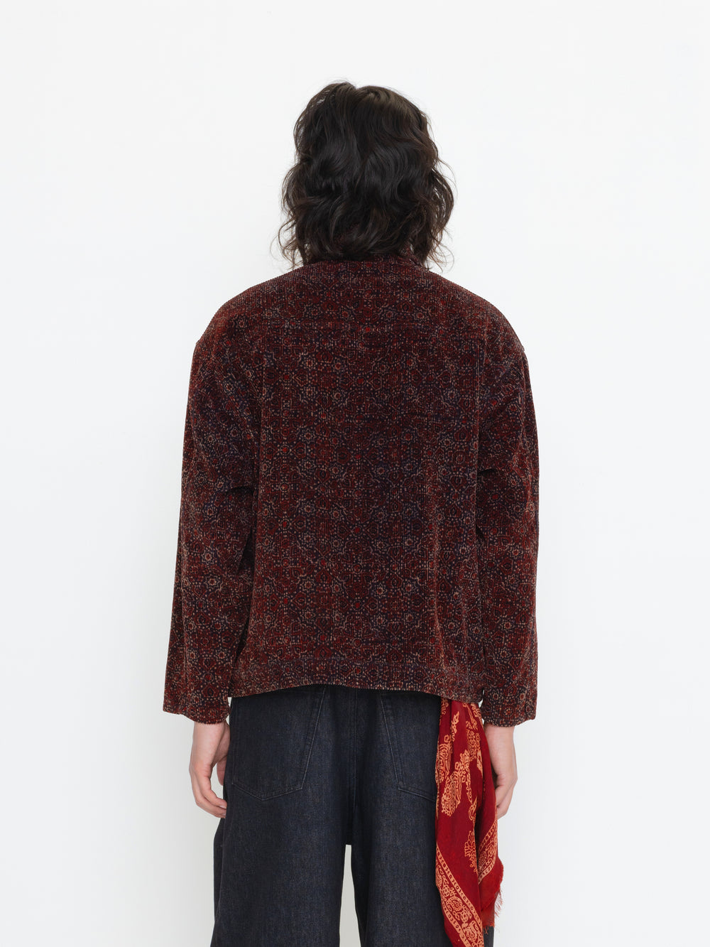 Person wearing a brown textured jacket with a white background