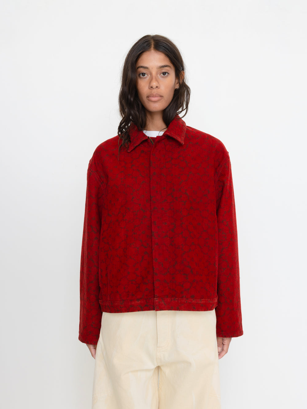Person wearing a red patterned jacket on a white background