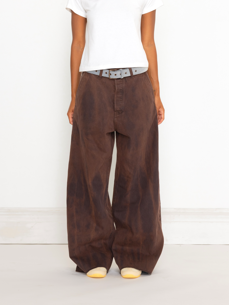 Person wearing brown wide-leg pants and a white shirt on a white background