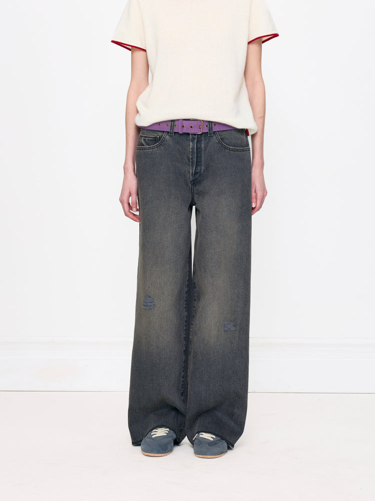 Person wearing wide-leg jeans and a white top on a white background