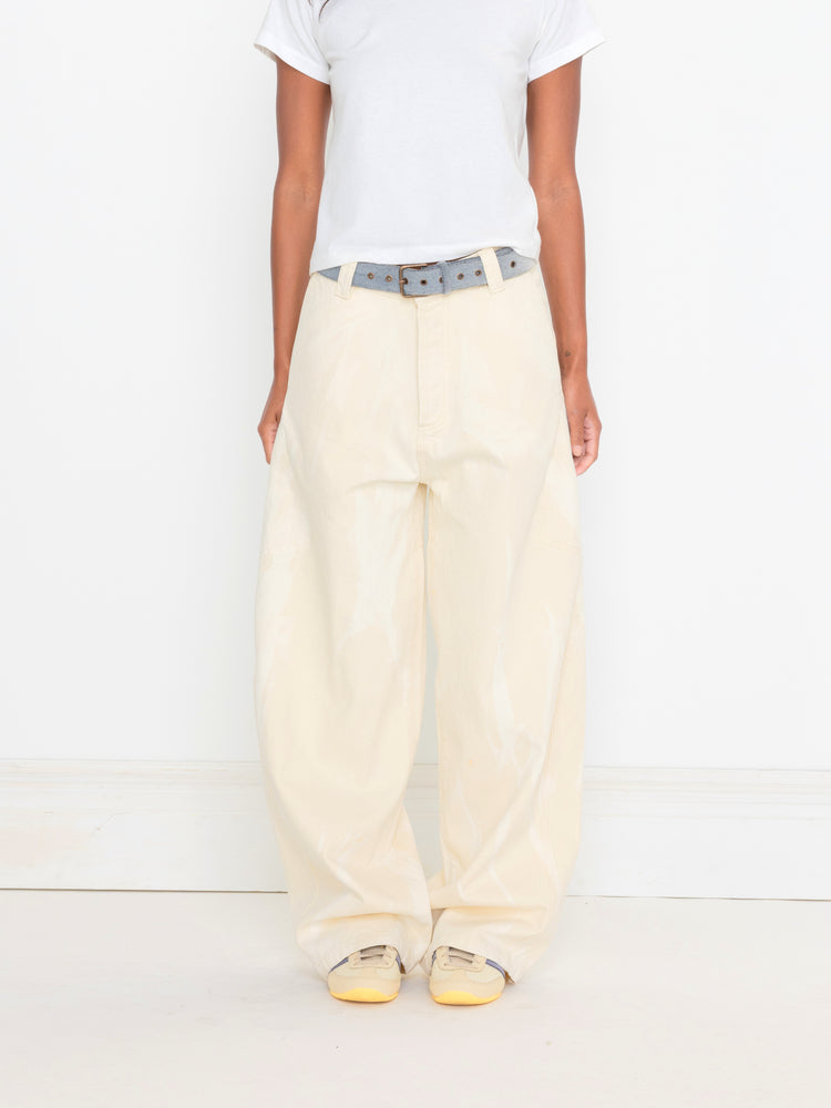 Person wearing cream-colored pants with a belt on a white background