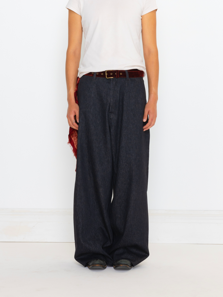Person wearing wide-leg dark jeans with a white shirt on a light background