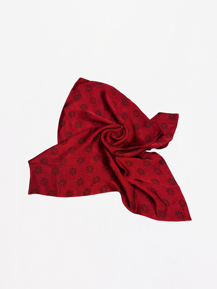 Red scarf with black pattern on a white background