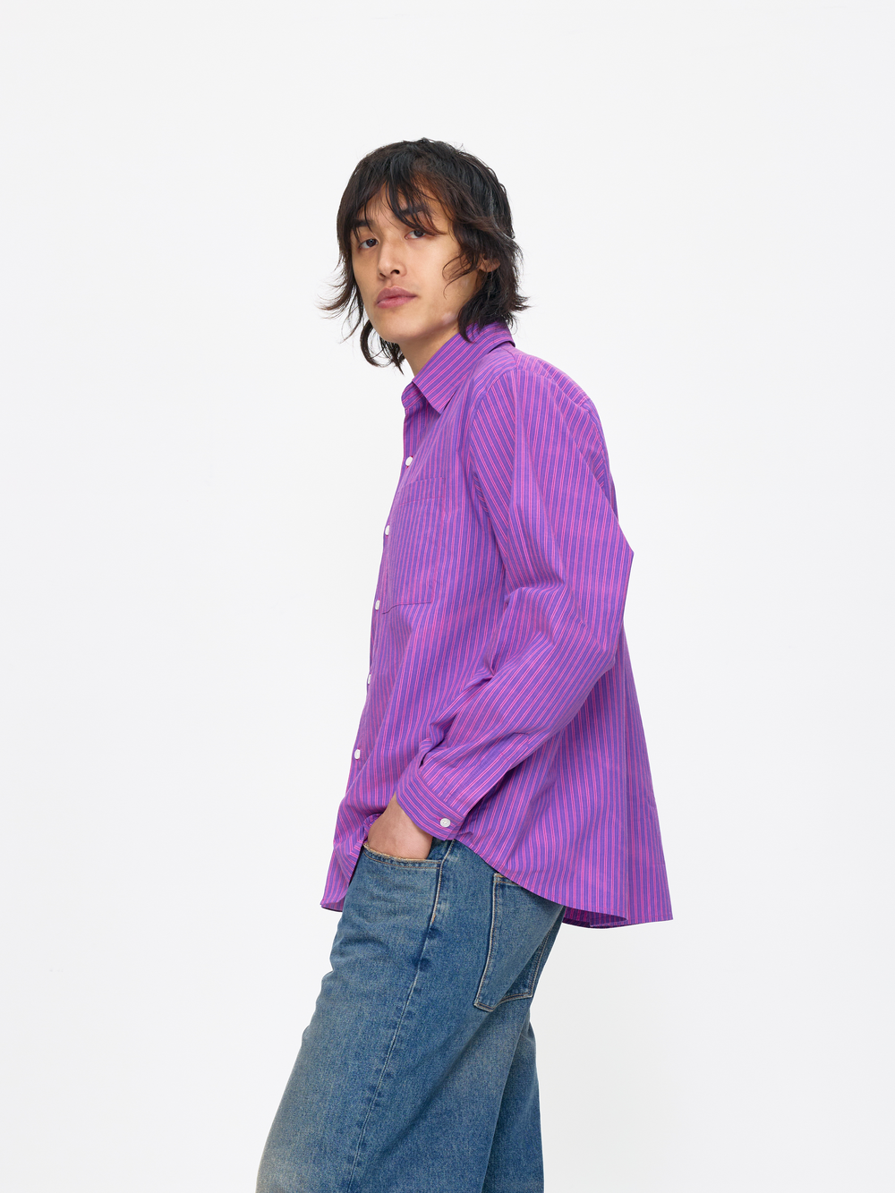 Person wearing a purple striped shirt and blue jeans on a white background