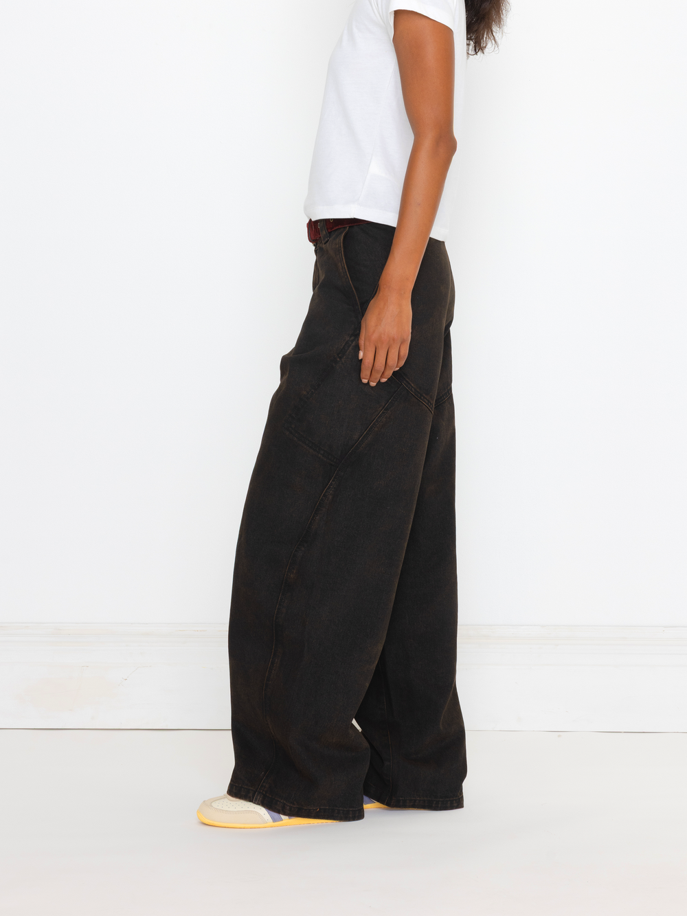 Person wearing black wide-leg pants and a white top on a white background