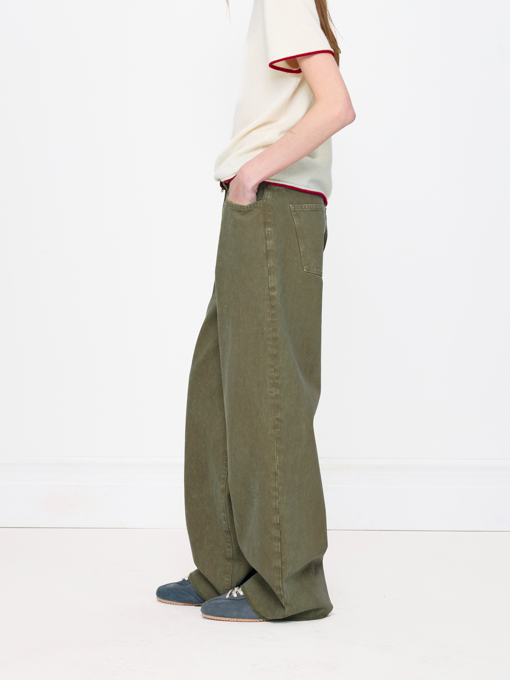 Person wearing olive green wide-leg pants on a white background