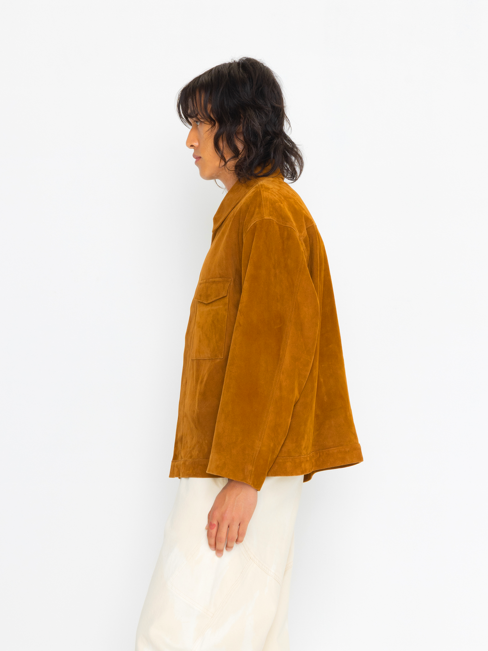 Person wearing a mustard yellow jacket on a white background