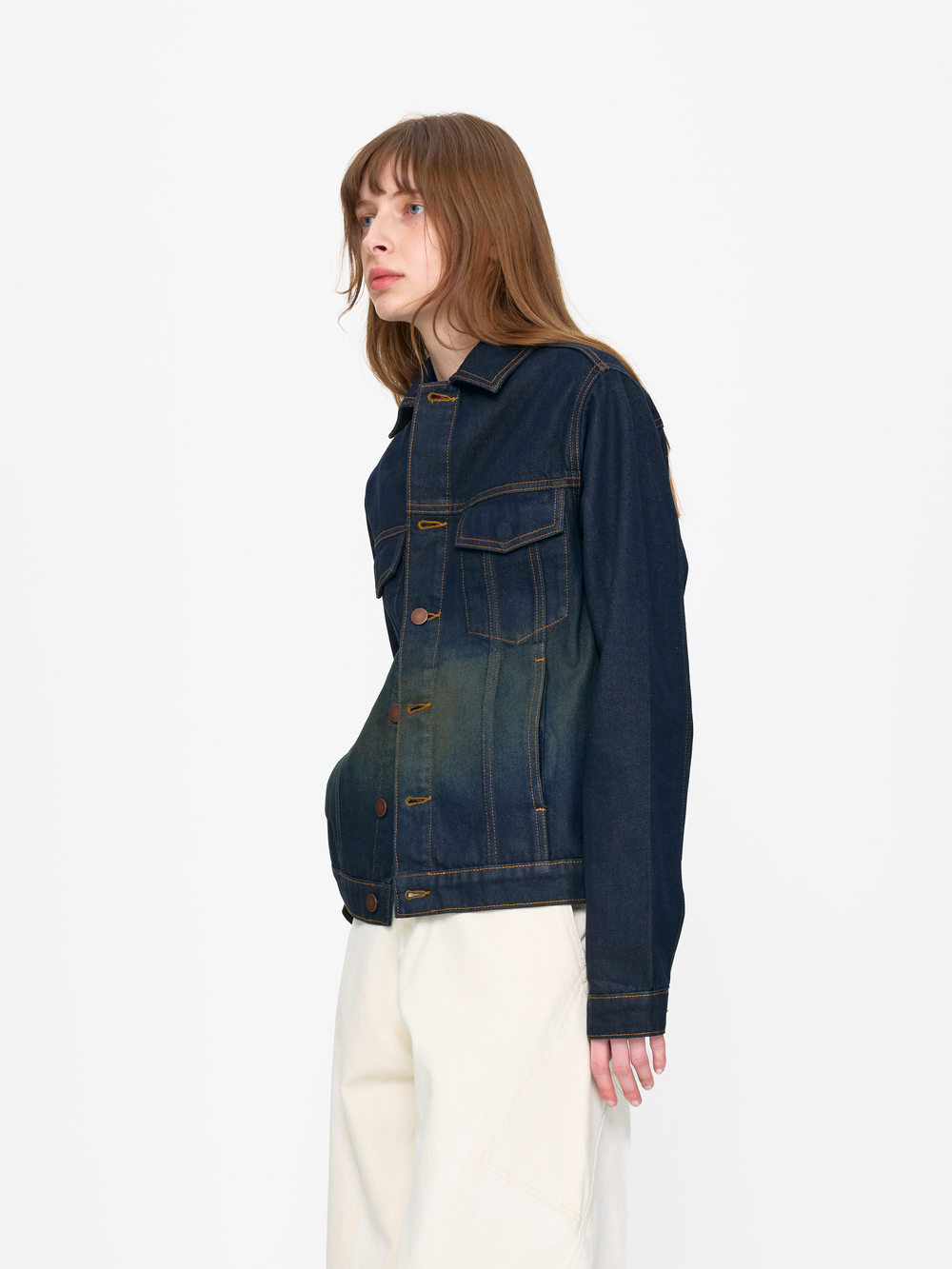 Person wearing a dark blue denim jacket on a white background